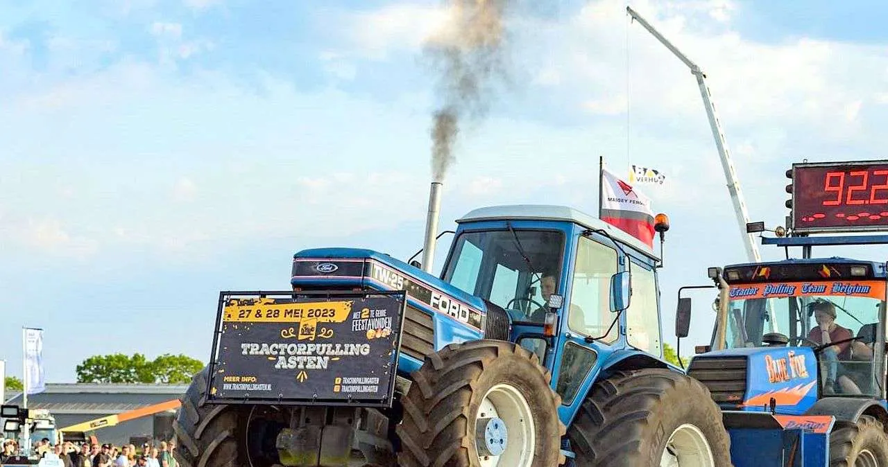 Een Ford TW-25 met een tractorpulling banner trekt de sleepwagen